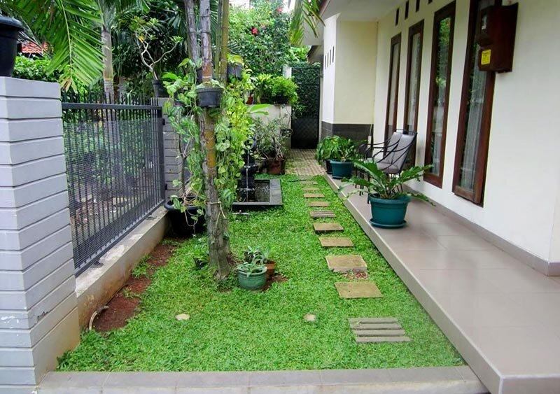 Khu vườn nhỏ tối giản dọc theo hiên nhà cấp 4 với thảm cỏ xanh và lối đi lát đá (Nguồn: Internet)