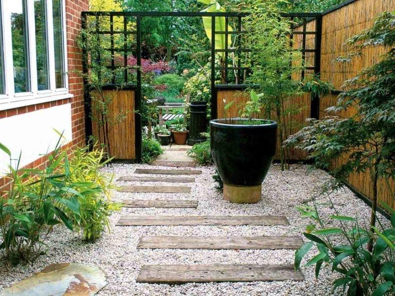 Góc sân vườn tối giản lát sỏi kết hợp chậu cây dáng lớn và thanh chắn gỗ (Nguồn: Internet)